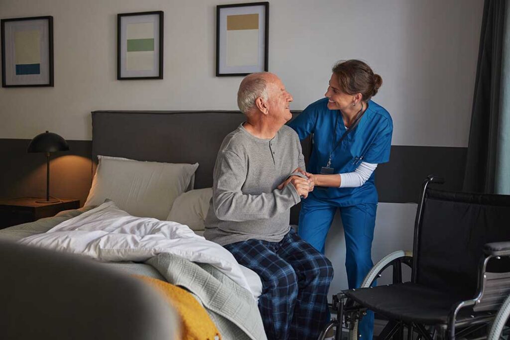 Social worker speaks with an older resident at a table with care notes and a family member nearby.